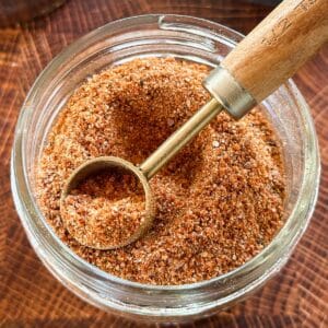 classic burger seasoning in a glass jar with a measuring spoon