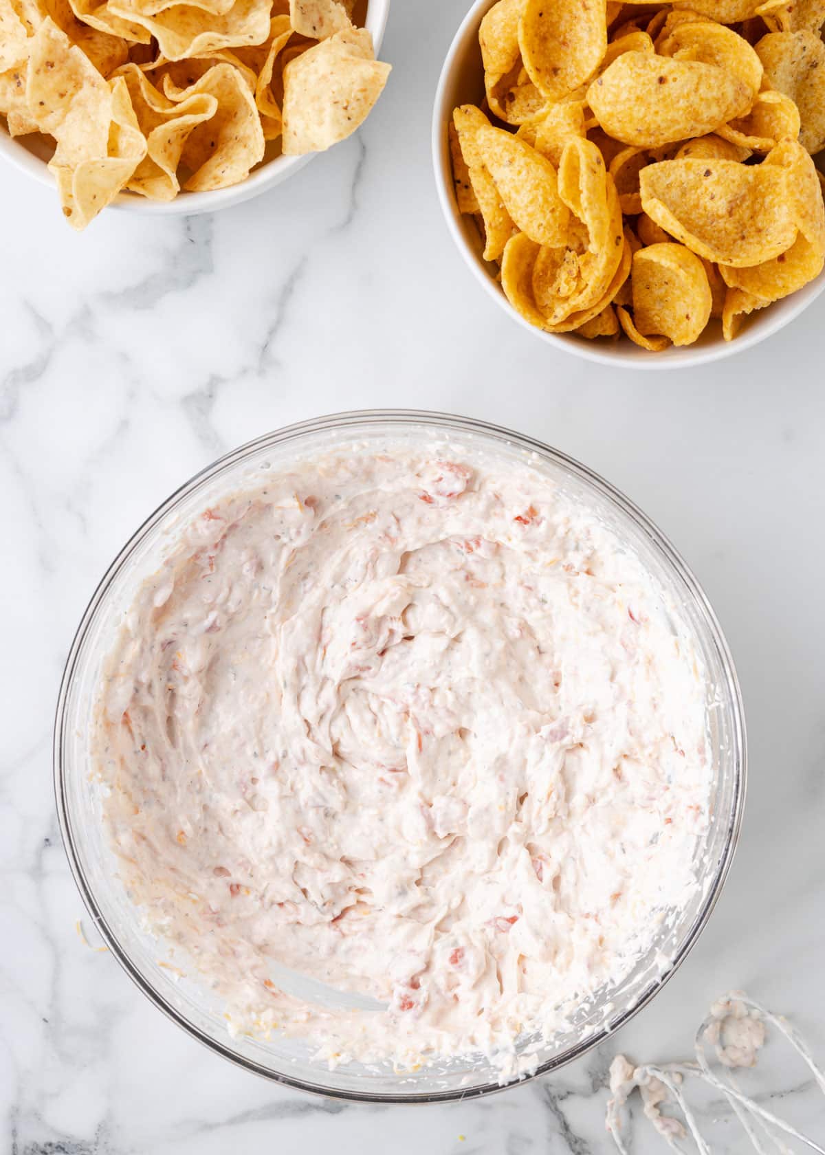 overhead of freshly mixed Boat Dip in a glass bowl on a marble board