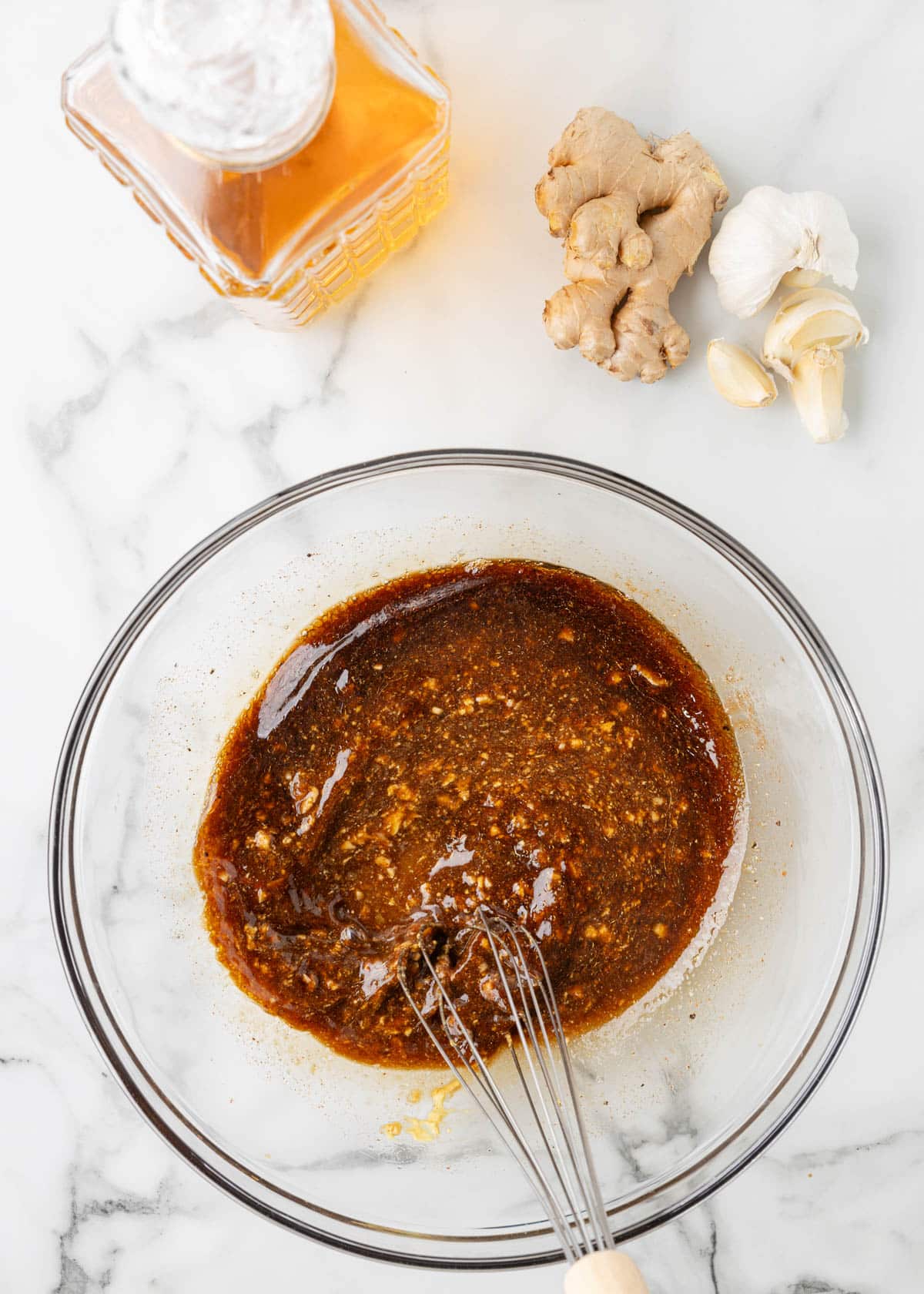 overhead of bourbon marinade ingredients being whisked together in a glass bowl