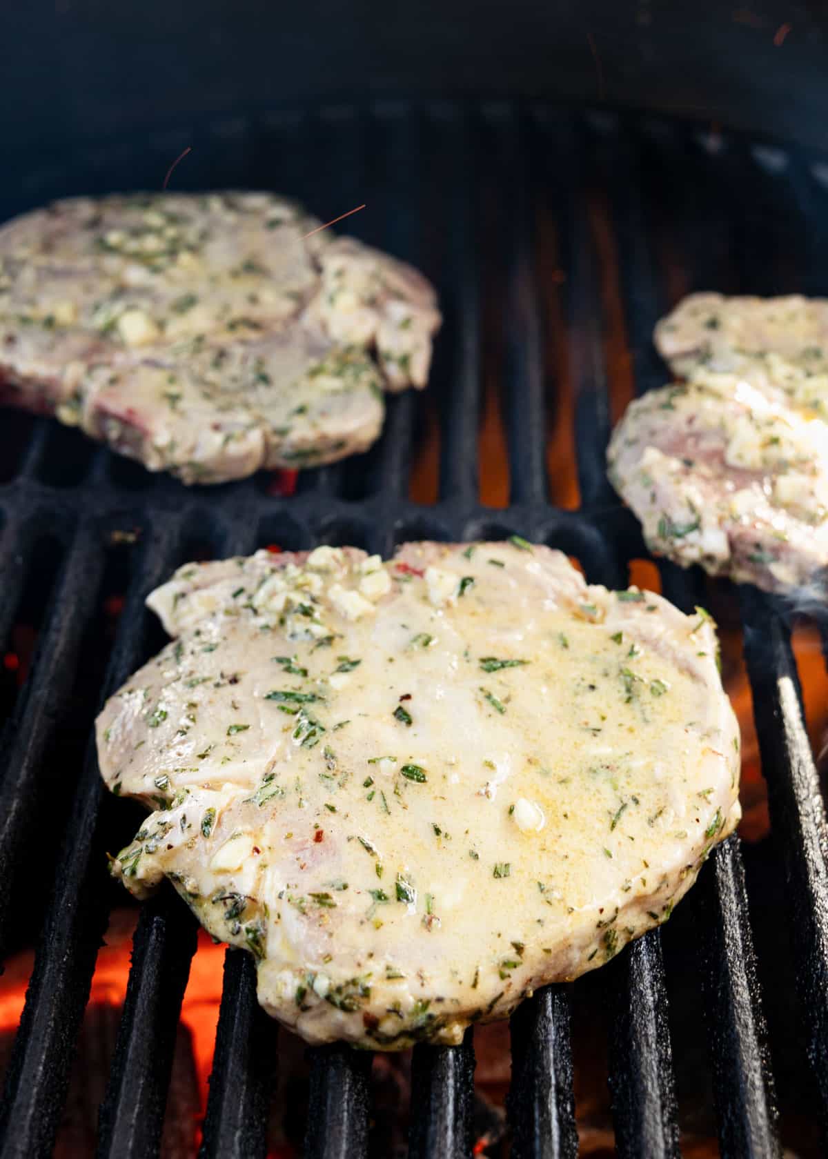 lemon herb marinated pork chops on a lit grill