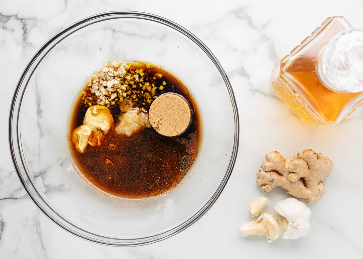 overhead of bourbon marinade ingredients in a glass bowl, unmixed