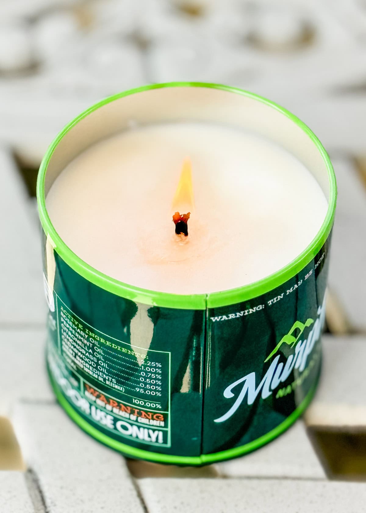 Murphy's repellant candle burning on a picnic table