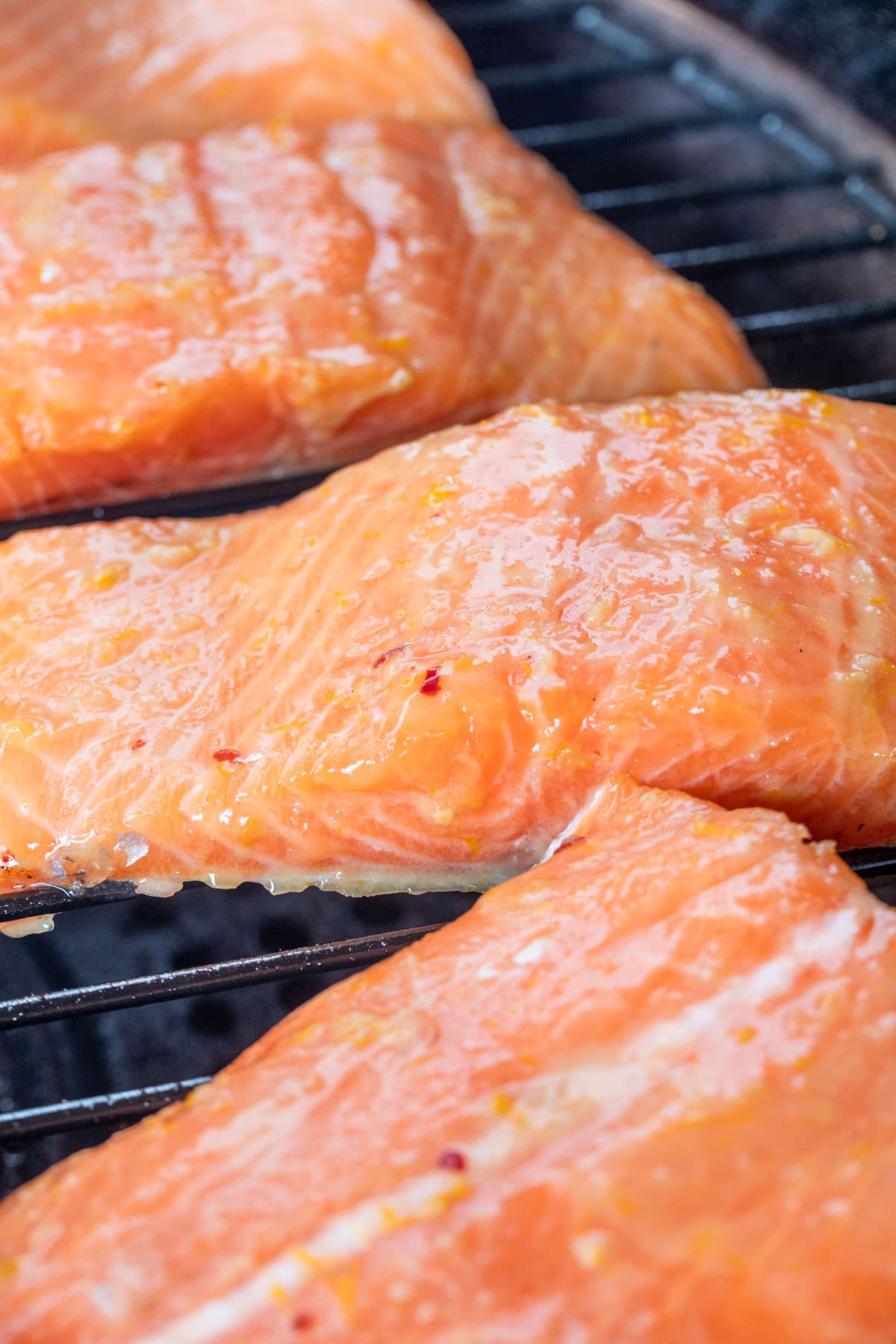 raw salmon fillets brushed with orange maple bourbon glaze on a pellet grill