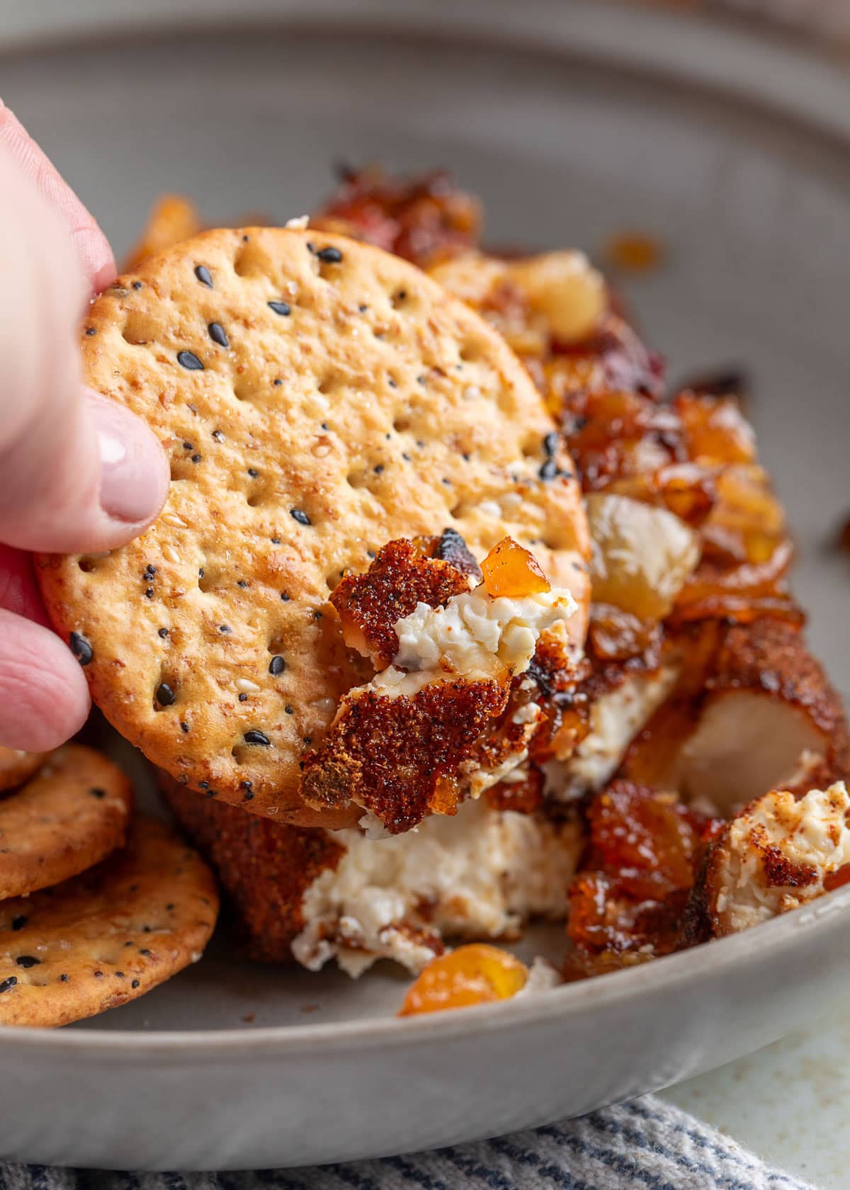 scooping smoked cream cheese onto a whole grain cracker