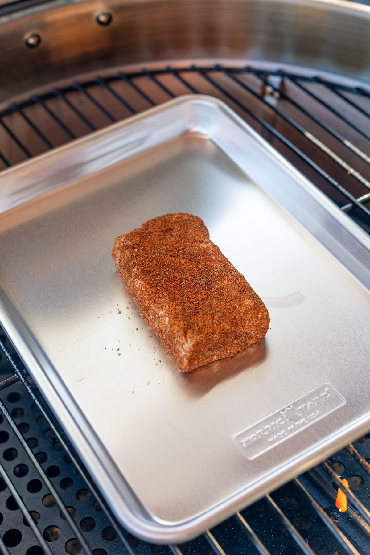 spice rubbed cream cheese on a baking sheet on a pellet grill