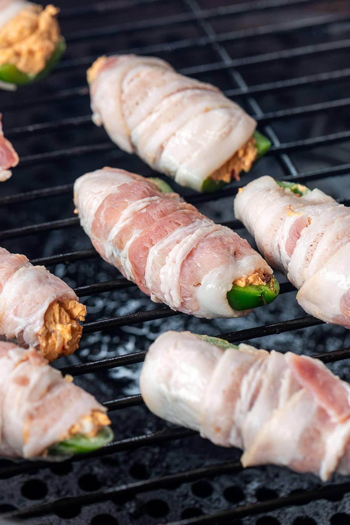 raw bacon wrapped jalapeno poppers on a pellet grill