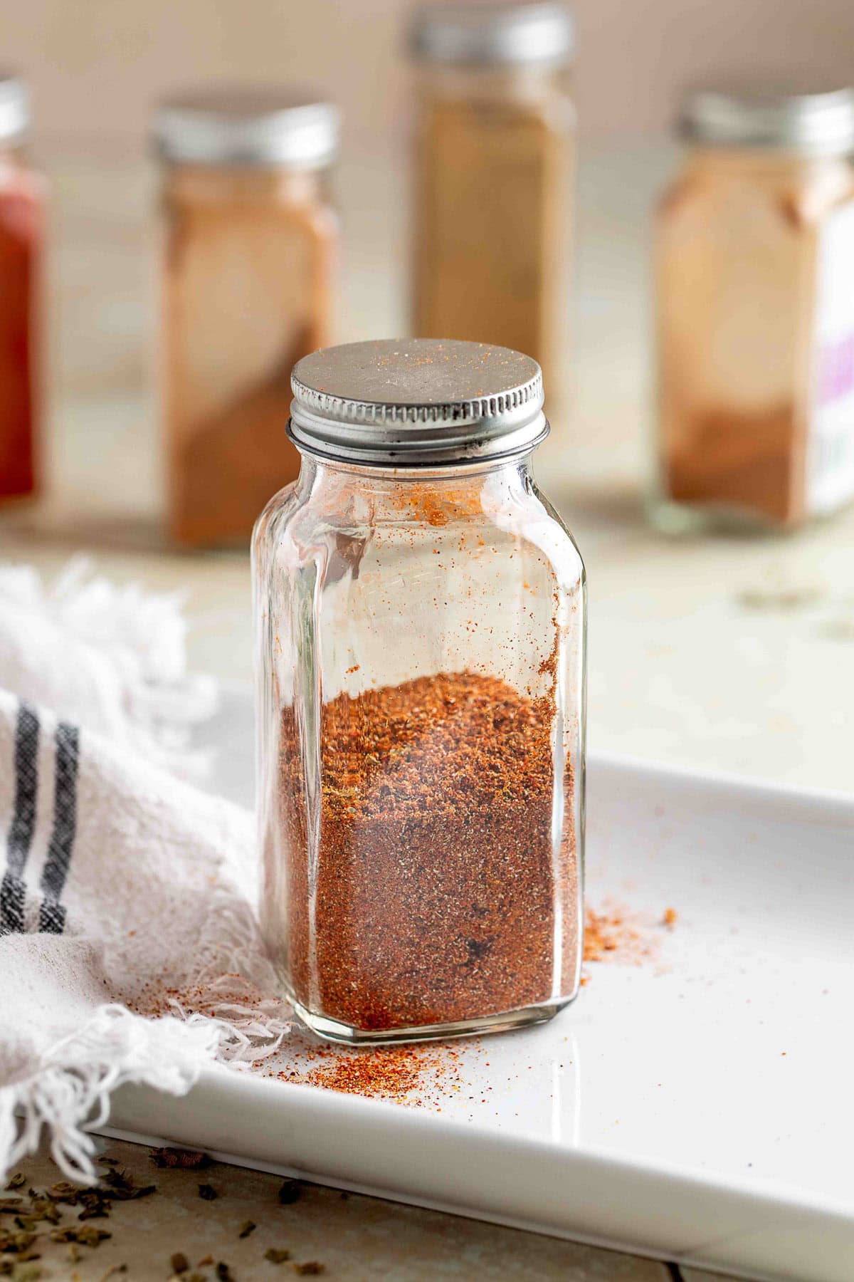 fajita seasoning in a glass spice jar on a white platter